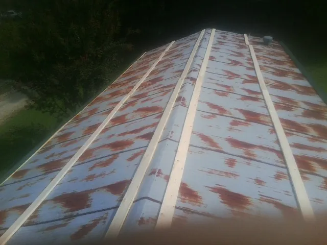 Rusted metal roof panels with new wood purlins before replacement — Storm Damage Roof Repair in Gaylord by Roofing Brothers